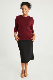 Model Noli wearing size L of The Keepers Soft Round Neck Jumper in colour Firered (Red), from the front, showing the whole outfit