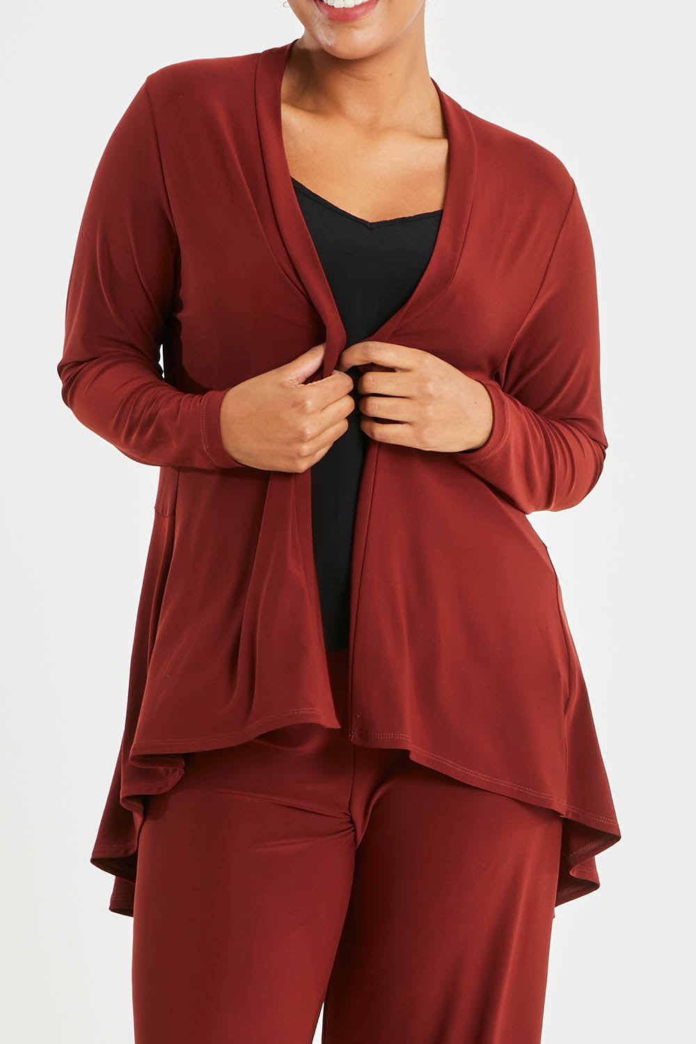 Model Noli wearing size 14 of The Recycled Flounce Cardigan in colour Terracotta, from the front, cropped image