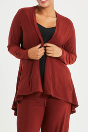 Model Noli wearing size 14 of The Recycled Flounce Cardigan in colour Terracotta, from the front, cropped image