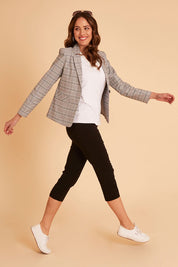 Model Madeline wearing size 10 of The Contour Capri Pant in colour Black (Black), from the front, showing the whole outfit