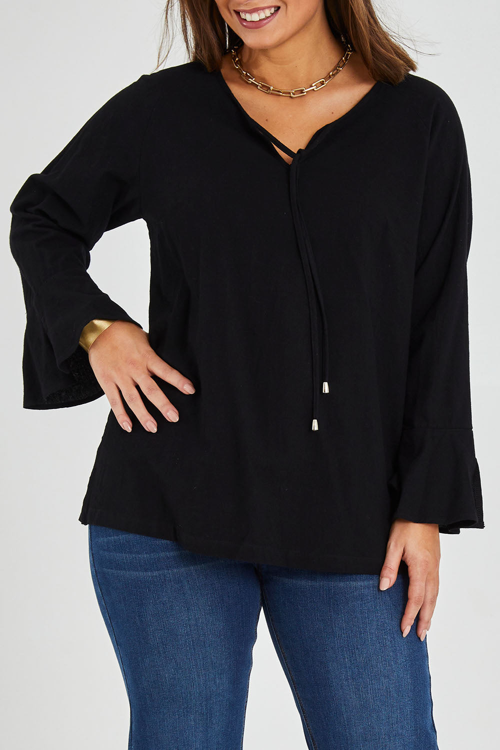 Model Monique wearing size 14 of The Fluted Sleeve Top in colour Black (Black), from the front, cropped image