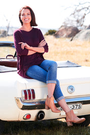 Model Perrie wearing size 10 of The V Neck Side Drape Tee in colour Wine (Purple), from the front, showing the whole outfit