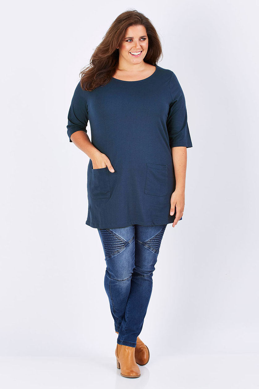 Model Mae wearing size 18 of The Pocket Tunic Top in colour Navy (Blue), from the front, showing the whole outfit