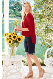 Model Denniel wearing size 10 of The Cross Over Blouse in colour Red (Red), from the front, showing the whole outfit