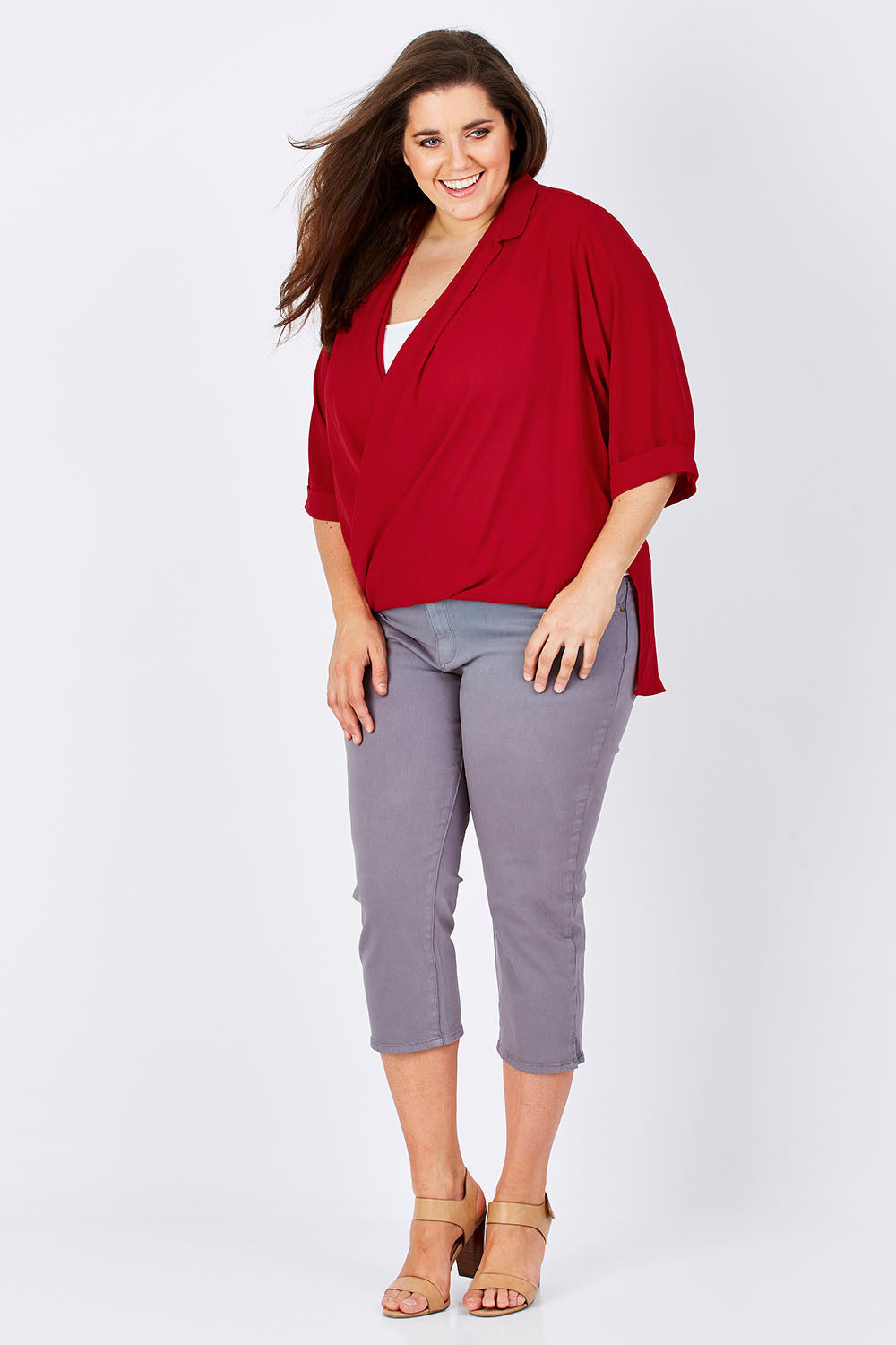 Model Mae wearing size 16 of The Cross Over Blouse in colour Red (Red), from the front, showing the whole outfit