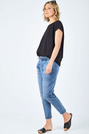 Model Chelsea wearing size 10 of The Pull On Jogger Jean in colour Denim (Blue), from the front, showing the whole outfit