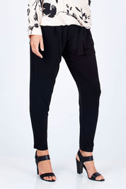 Model Riina wearing size 10 of The Comfort Pant in colour Black (Black), from the front, cropped image