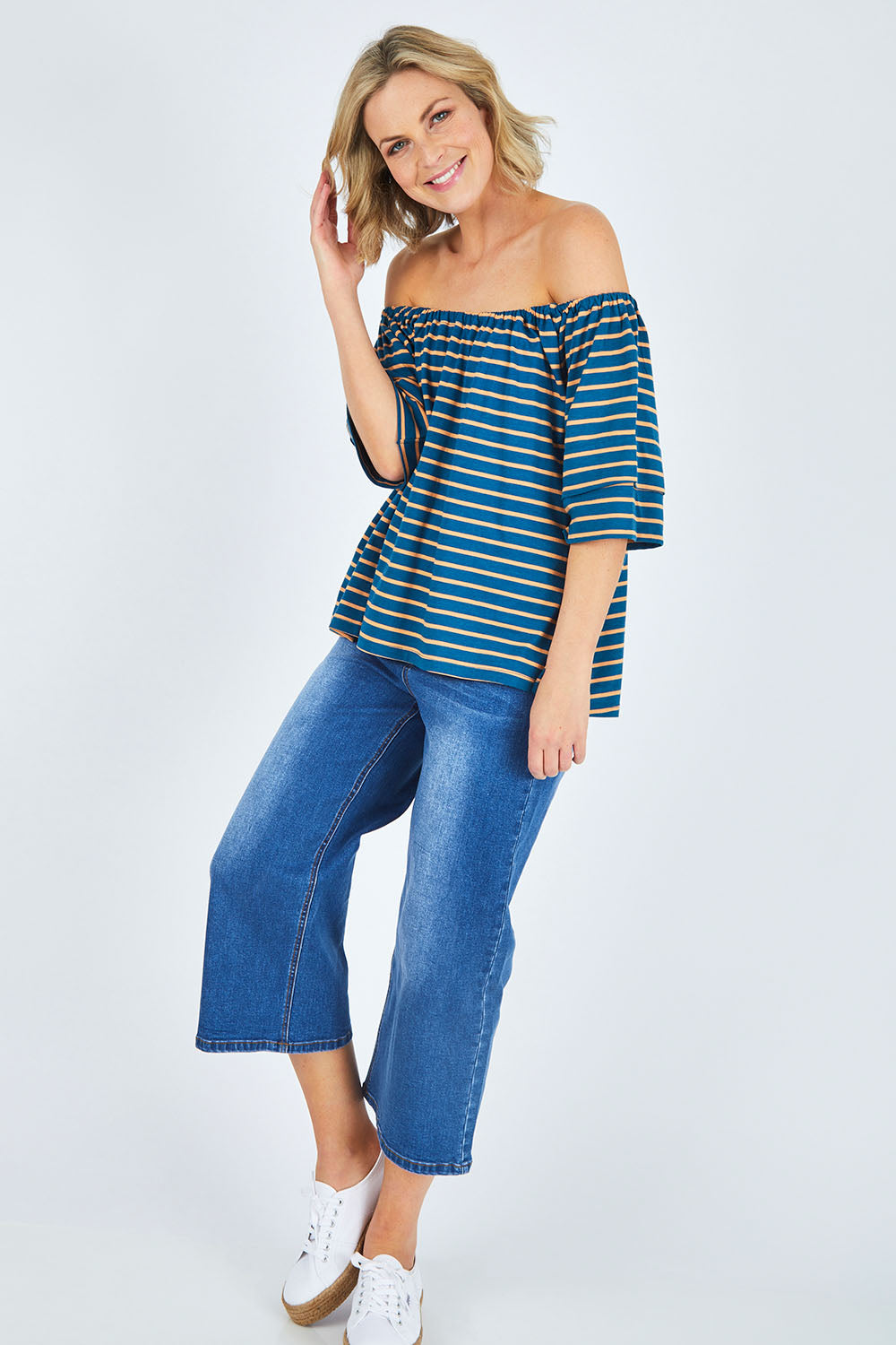 Model Chelsea wearing size 10 of The Cotton Bamboo Free Shoulder Top in colour Bluegold (Blue), from the front, showing the whole outfit