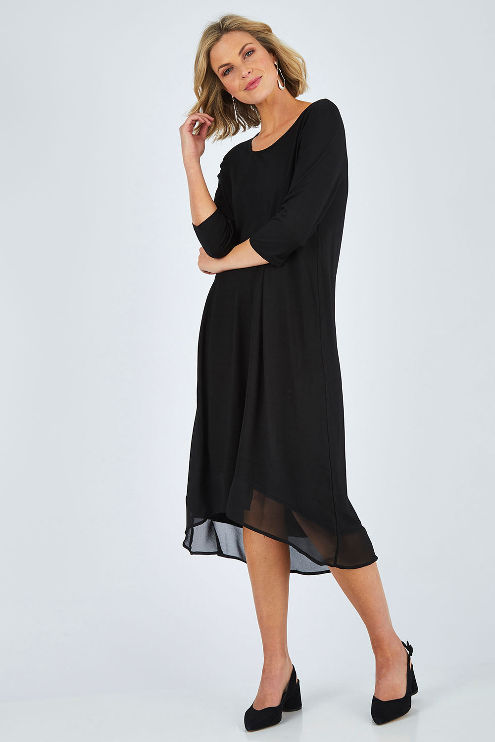 Model Chelsea wearing size 10 of The Chiffon Trim Dress in colour Black (Black), from the front, showing the whole outfit