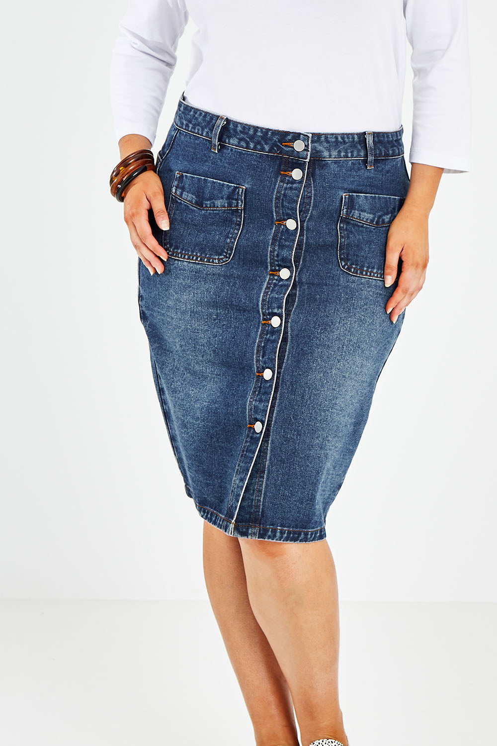 Model Jess wearing size 14 of The Midi Button Up Skirt in colour Darkdenim (Blue), from the front, cropped image