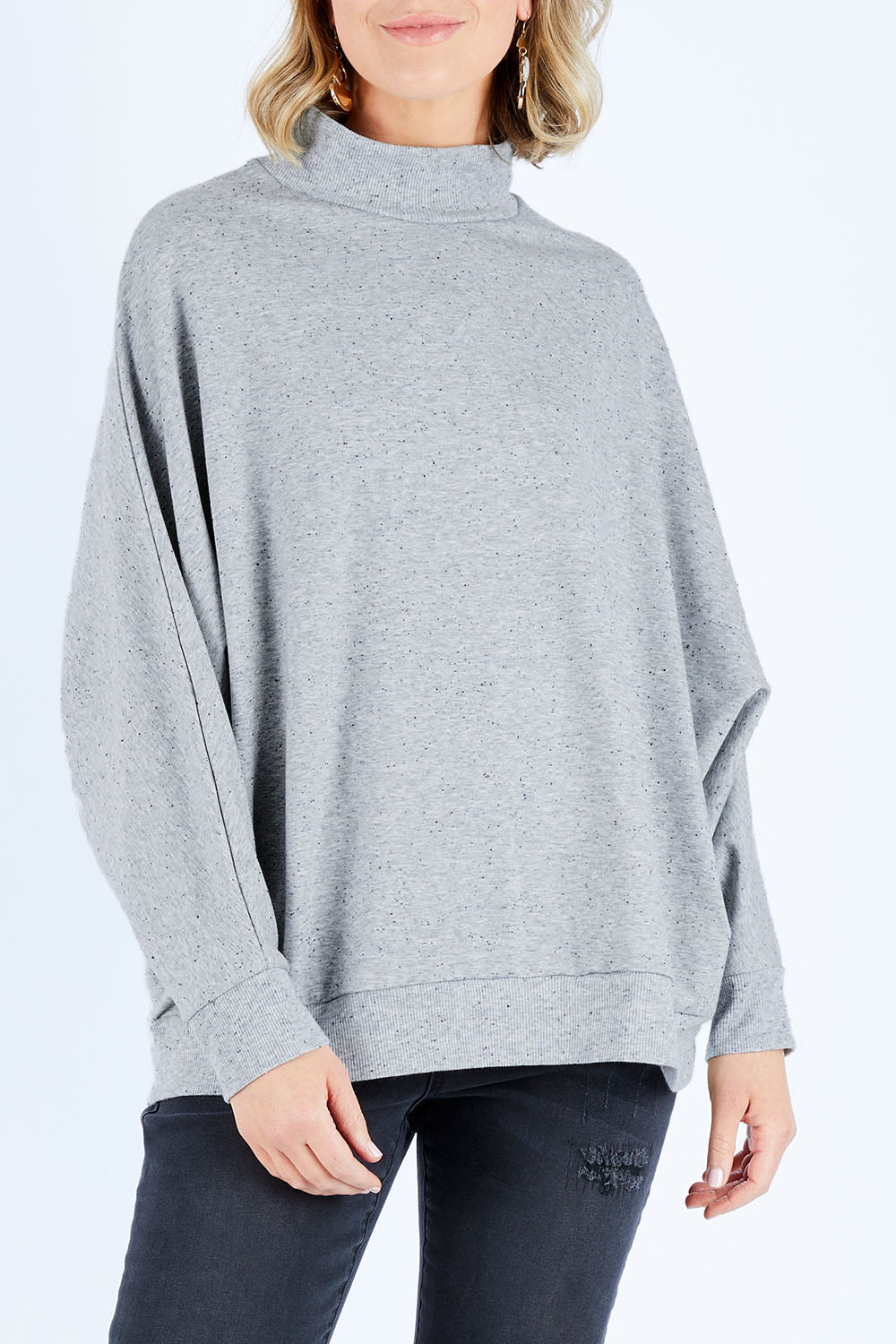 Model Chelsea wearing size S of The Batwing Jumper in colour Greyfleck (Grey), from the front, cropped image