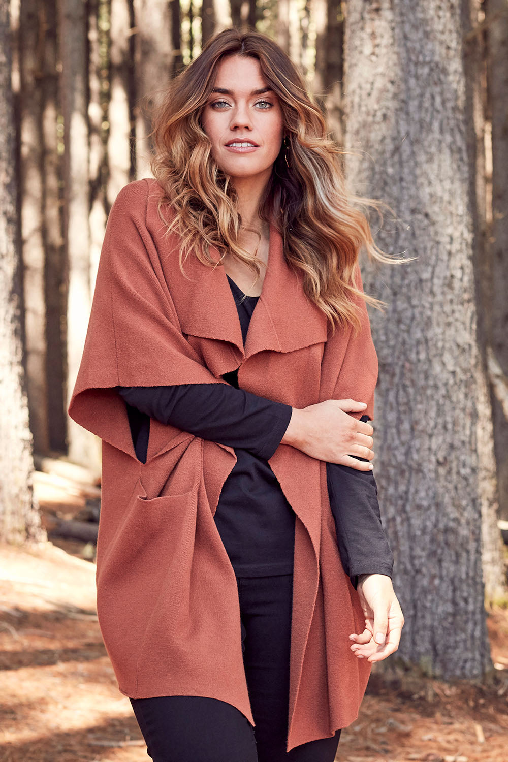 Model Laura wearing size OneSize of The Oversized Cape in colour Rust, from the front, showing the whole outfit