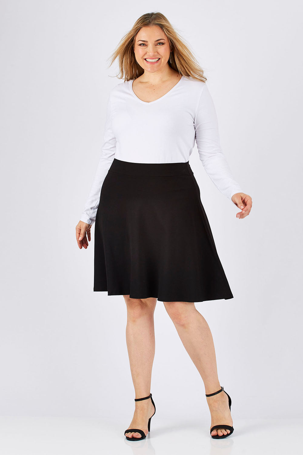 Model Ljubenka wearing size 18 of The Ponte Flip Skirt in colour Black (Black), from the front, showing the whole outfit