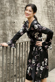 Model Miranda wearing size 10 of The Define Printed Wrap Dress in colour Floral (Black), from the front, cropped image