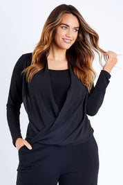 Model Laura wearing size 14 of The Faux 2 Piece Crossover Top in colour Black (Black), from the front, cropped image