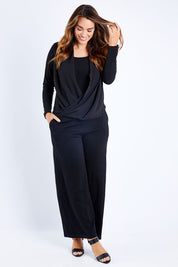 Model Laura wearing size 14 of The Faux 2 Piece Crossover Top in colour Black (Black), from the front, showing the whole outfit