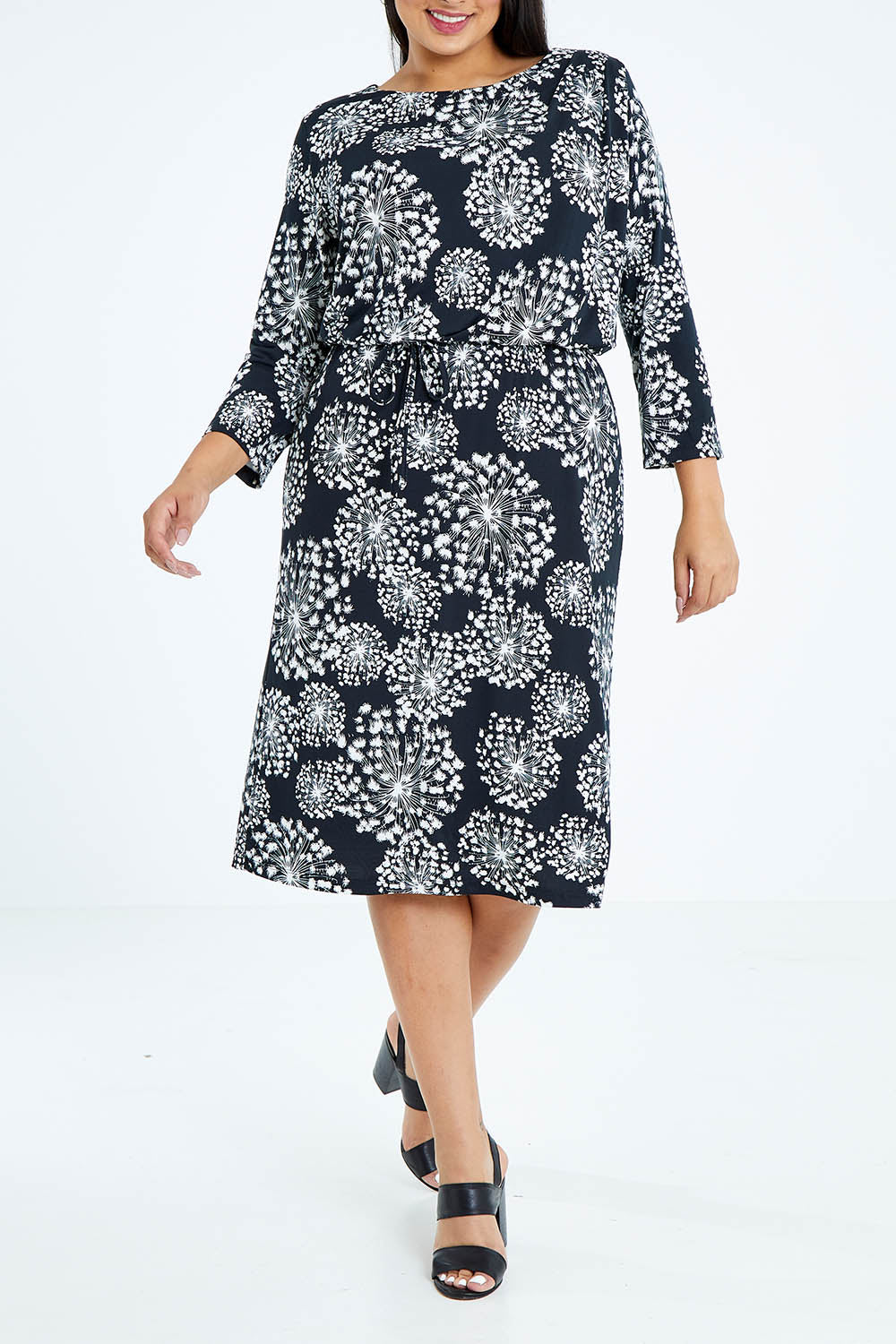 Model Sasha-Lee wearing size 16 of The Lined Jersey Dress in colour Blooms (Black), from the front, cropped image