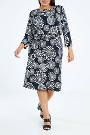 Model Sasha-Lee wearing size 16 of The Lined Jersey Dress in colour Blooms (Black), from the front, cropped image