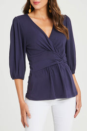 Model Madeline wearing size 10 of The Bamboo Knot Waist Detail Blouse in colour Darknavy (Blue), from the front, cropped image