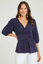 Model Madeline wearing size 10 of The Bamboo Knot Waist Detail Blouse in colour Darknavy (Blue), from the front, cropped image