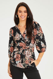 Model Stacey wearing size 10 of The Knot Waist Detail Blouse in colour Blackfleur (Black), from the front, cropped image