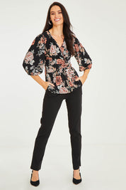 Model Stacey wearing size 10 of The Knot Waist Detail Blouse in colour Blackfleur (Black), from the front, showing the whole outfit