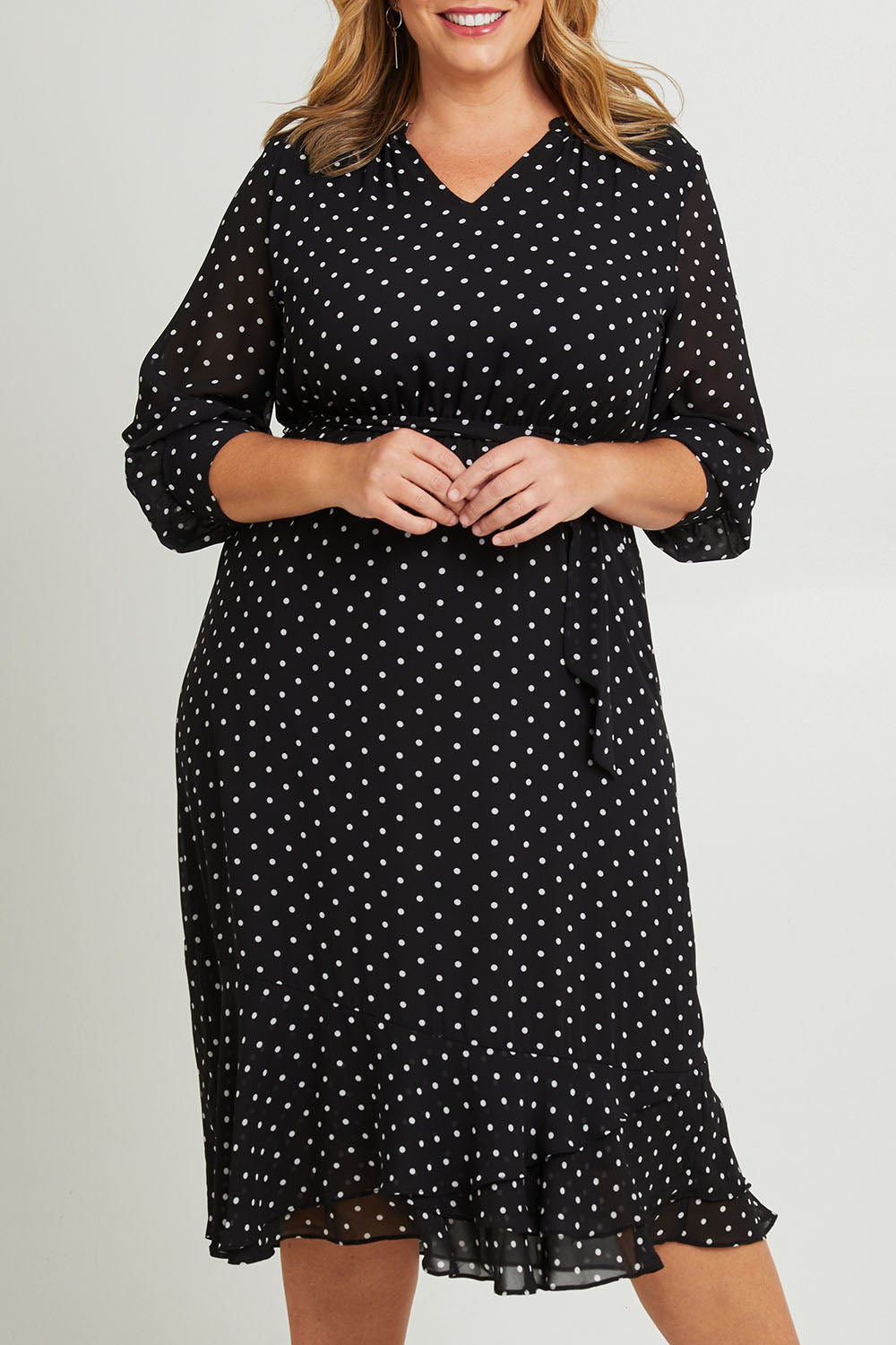 Model Fiona wearing size 16 of The Printed Chiffon Puff Sleeve Dress in colour Polkadot (Black), from the front, cropped image