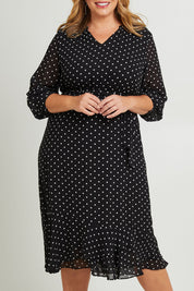 Model Fiona wearing size 16 of The Printed Chiffon Puff Sleeve Dress in colour Polkadot (Black), from the front, cropped image