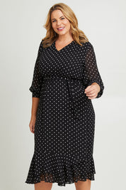 Model Fiona wearing size 16 of The Printed Chiffon Puff Sleeve Dress in colour Polkadot (Black), from the front, cropped image