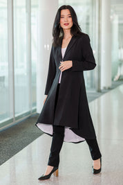 Model Miranda wearing size 10 of The Tailored Longline Jacket in colour Black (Black), from the front, showing the whole outfit