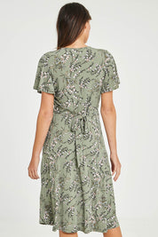Model Madeline wearing size 10 of The Printed Jersey Faux Wrap Dress in colour Fleur (Green), from the back
