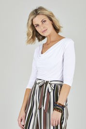 Model Chelsea wearing size 10 of The Reversible Cowl Neck Top in colour White (White), from the front, cropped image