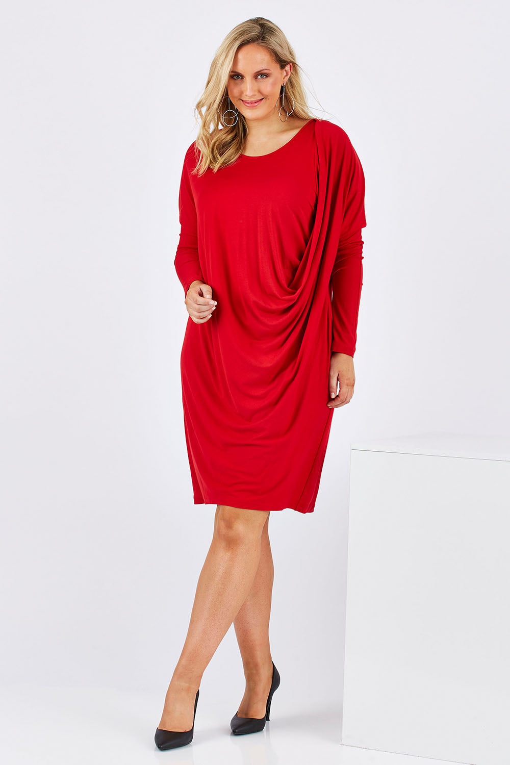 Model Jess wearing size 12 of the Belle Jersey Drapey Dress in colour Red (Red), from the front, showing the whole outfit