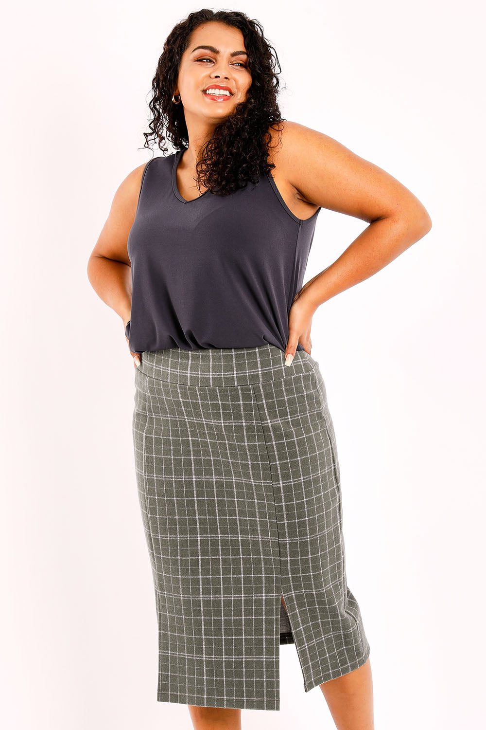 Model Sasha-Lee wearing size 16 of the Belle Check Cotton Rich Pencil Skirt in colour Check (Green), from the front, cropped image