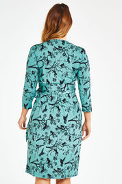Model Laura wearing size 12 of the Belle Bird Print Wrap Dress in colour Bird (Green), from the back