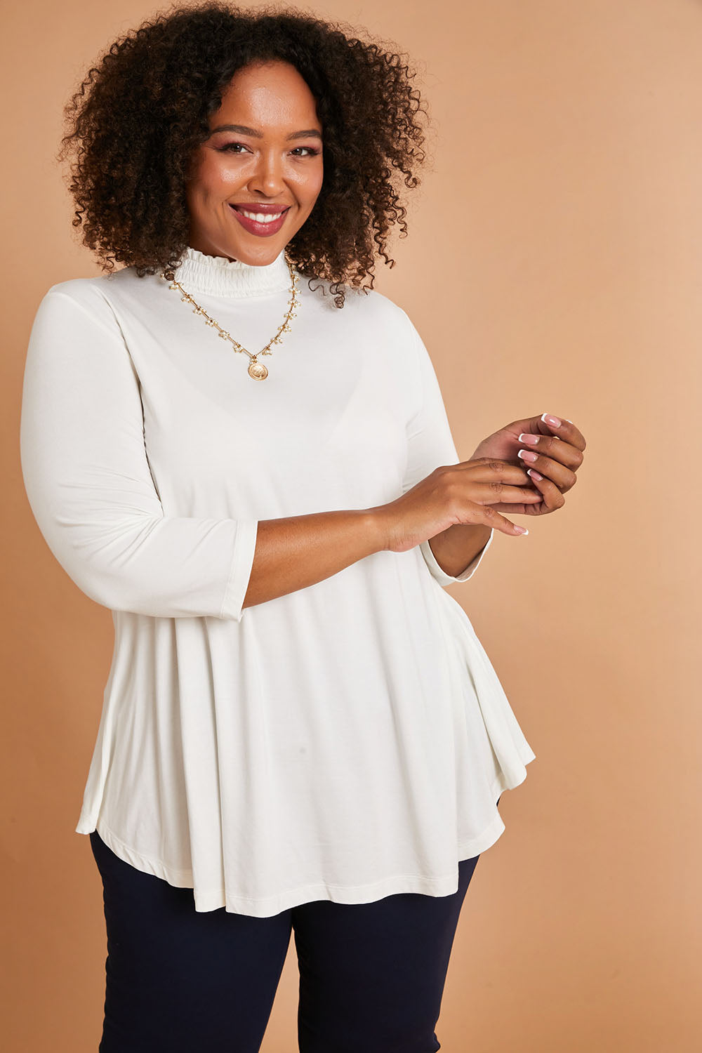 Model Alexis wearing size 16 of the Belle Turtleneck Draped Bamboo Tee in colour Ivory (White), from the front, showing the whole outfit