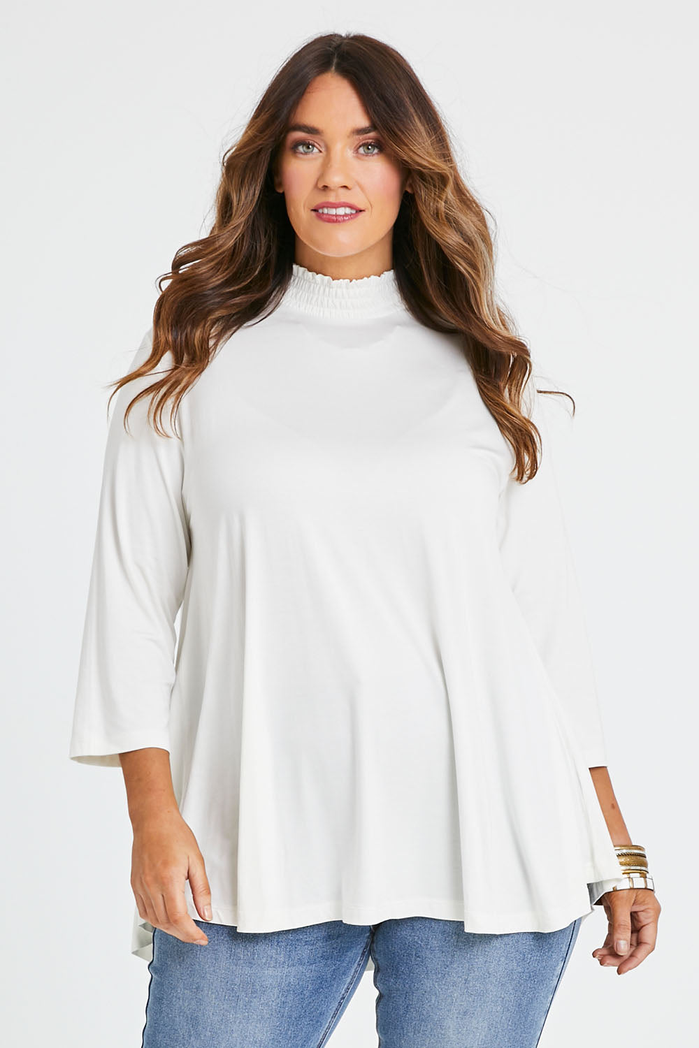 Model Laura wearing size 14 of the Belle Turtleneck Draped Bamboo Tee in colour Ivory (White), from the front, cropped image