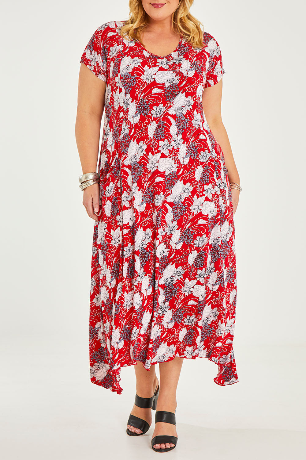 Model Caitlin wearing size 20 of the Belle High Low Dress With Pockets in colour Redfloral (Red), from the front, cropped image