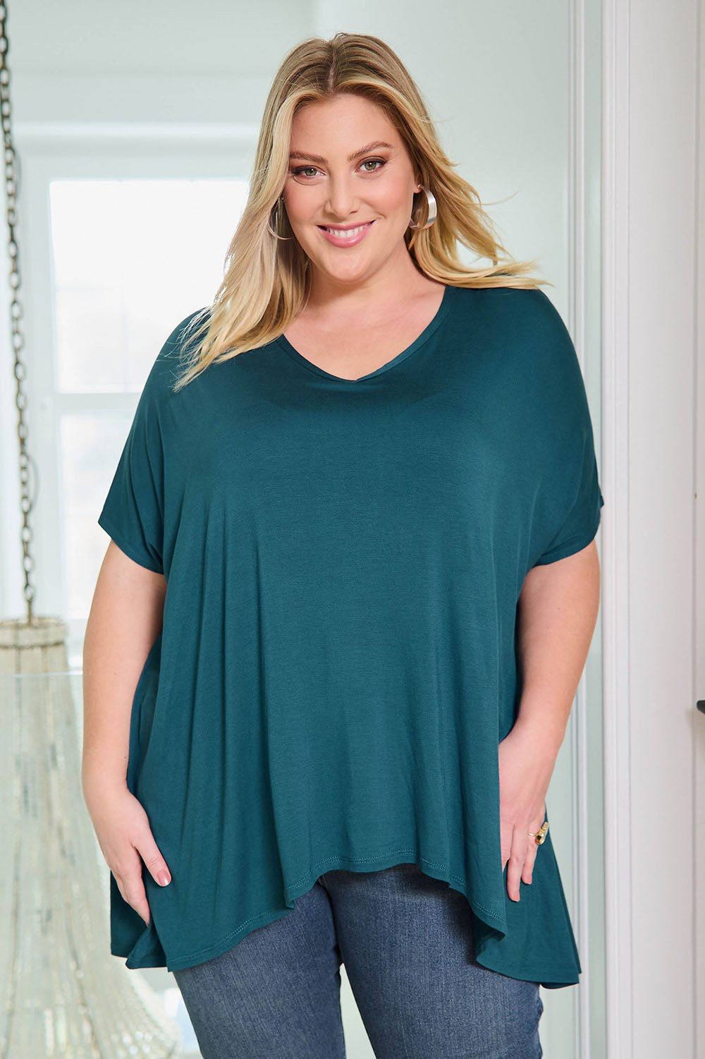 Model Caitlin wearing size 18 of the Belle High Low Bamboo Tee in colour Petrol (Blue), from the front, showing the whole outfit