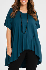 Model Laura wearing size 14 of the Belle High Low Bamboo Tee in colour Petrol (Blue), from the front, cropped image