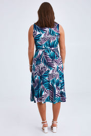 Model Monique wearing size 14 of the Belle Sleeveless Full Skirt Dress in colour Palmprint (Blue), from the back