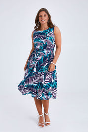 Model Monique wearing size 14 of the Belle Sleeveless Full Skirt Dress in colour Palmprint (Blue), from the front, showing the whole outfit