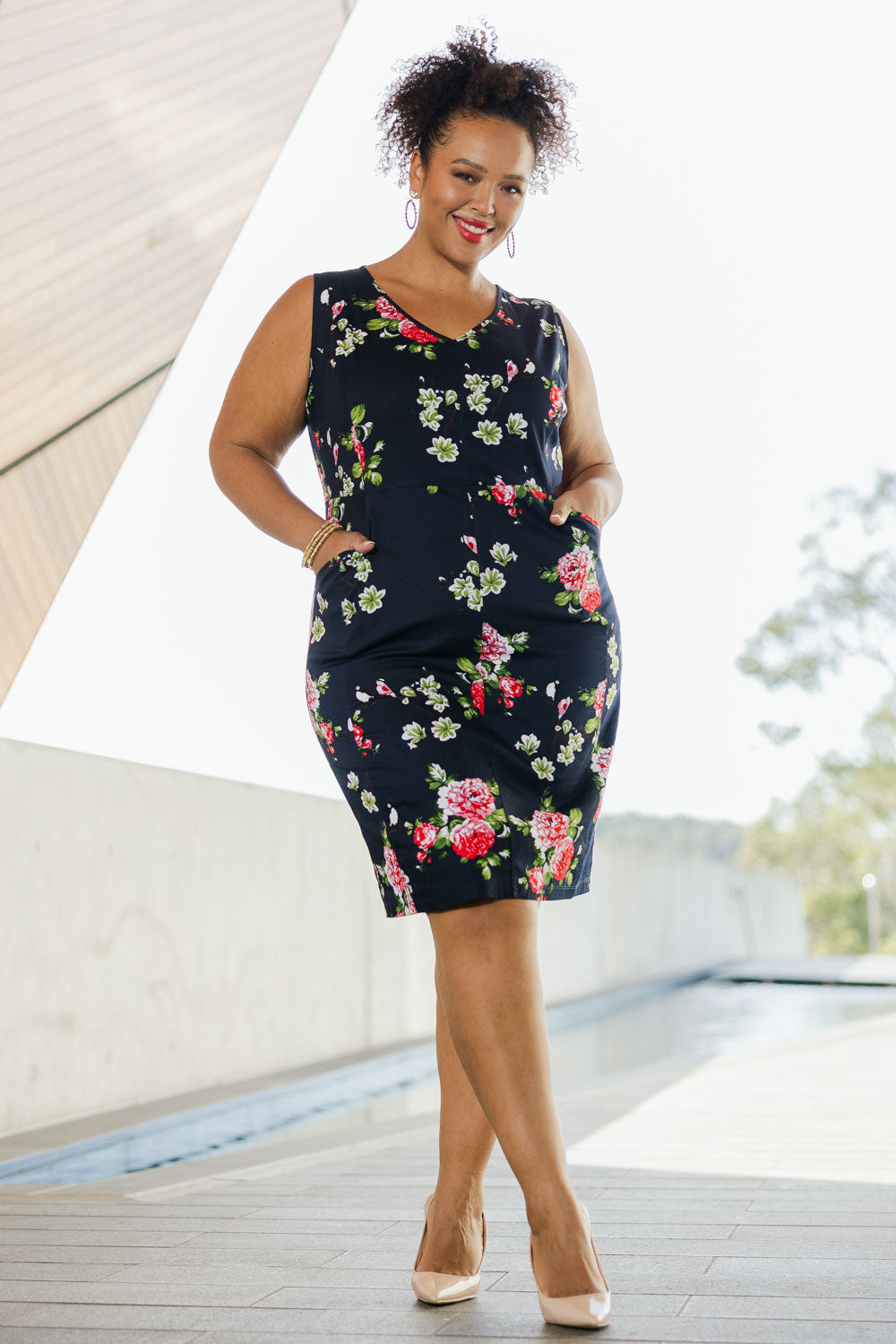 Model Alexis wearing size 18 of the Belle V Neck Cotton Sateen Print  Dress in colour Bluefloral (Blue), from the front, showing the whole outfit