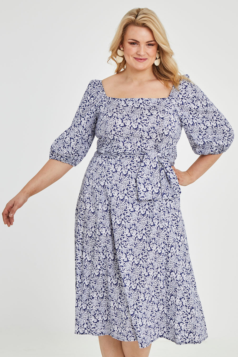 Model Keeara wearing size 16 of the Walking On Sunshine Dress in colour Navypais (Blue), from the front, cropped image