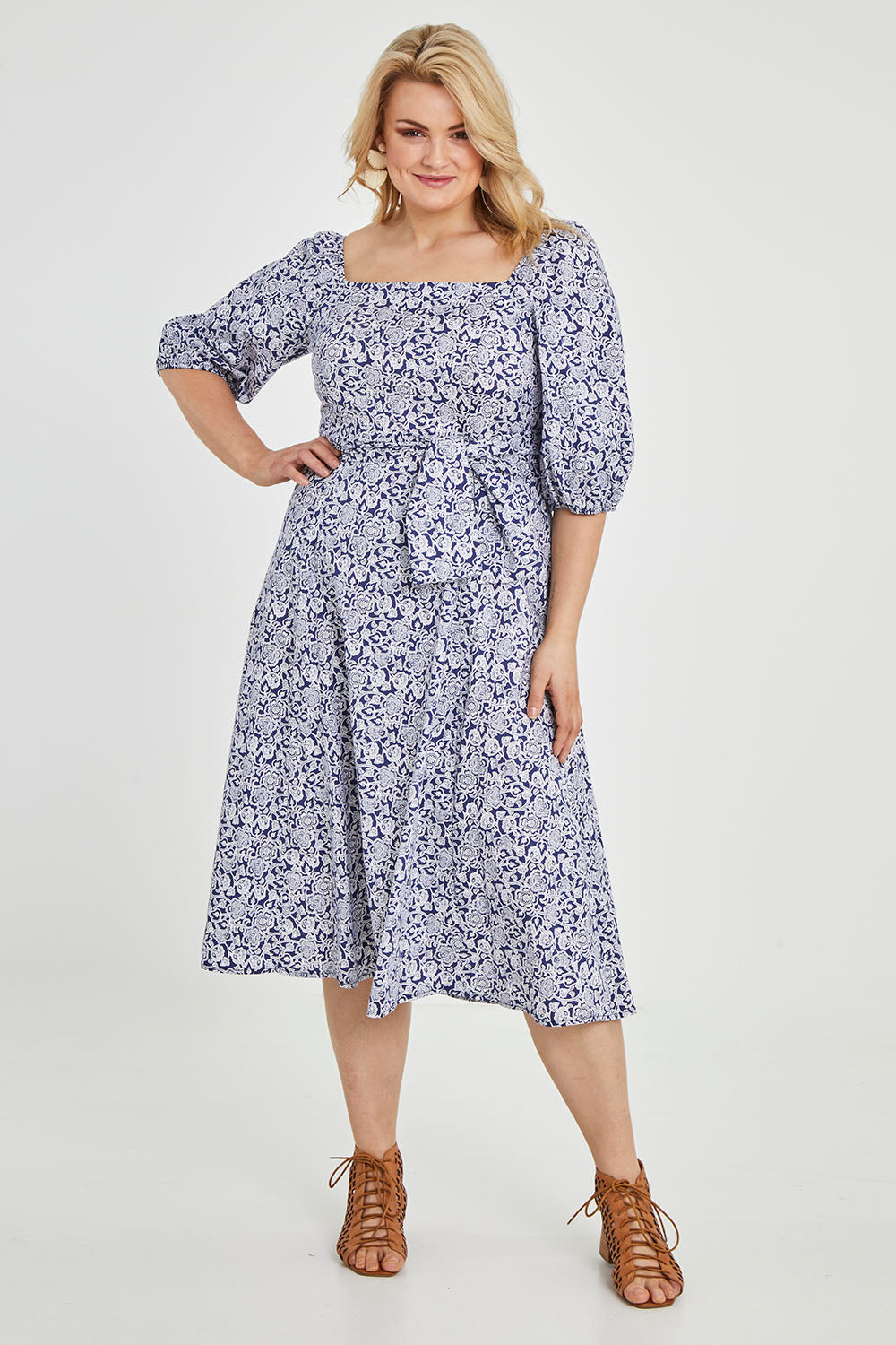 Model Keeara wearing size 16 of the Walking On Sunshine Dress in colour Navypais (Blue), from the front, showing the whole outfit