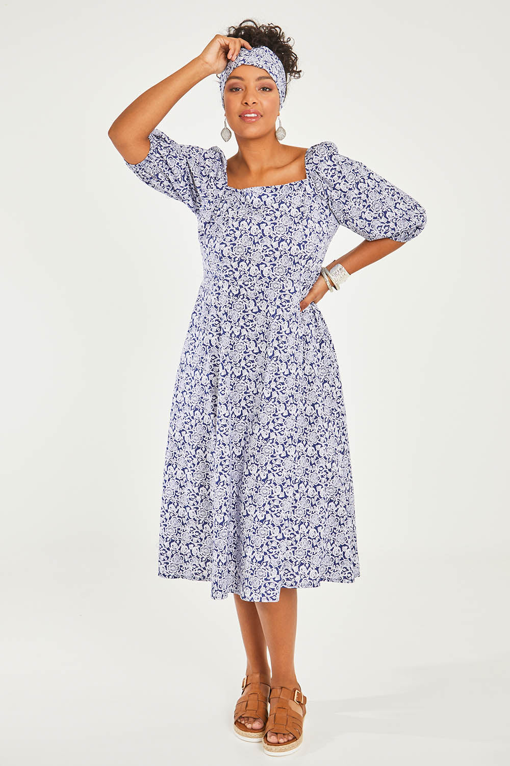 Model Noli wearing size 14 of the Walking On Sunshine Dress in colour Navypais (Blue), from the front, showing the whole outfit