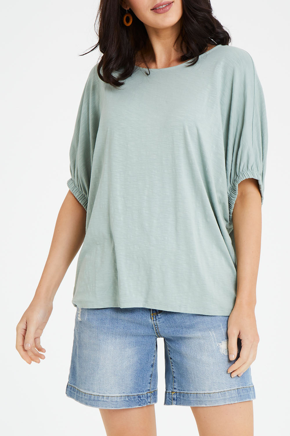 Model Andrea wearing size 10 of the In My Arms Tee in colour Sage (Green), from the front, cropped image