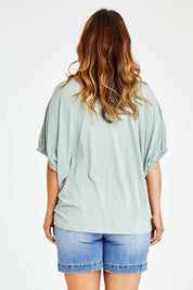 Model Laura wearing size 14 of the In My Arms Tee in colour Sage (Green), from the back