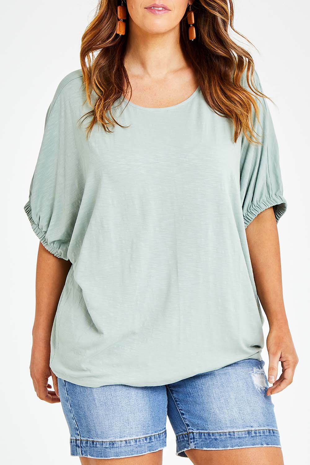 Model Laura wearing size 14 of the In My Arms Tee in colour Sage (Green), from the front, cropped image