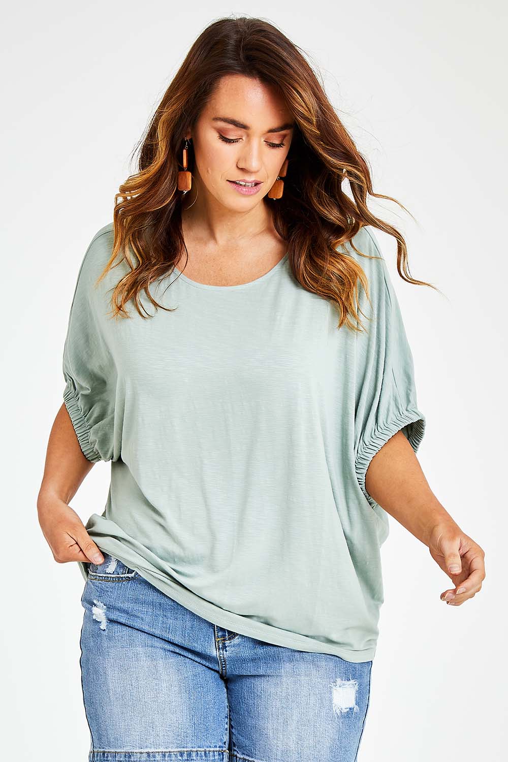 Model Laura wearing size 14 of the In My Arms Tee in colour Sage (Green), from the front, cropped image